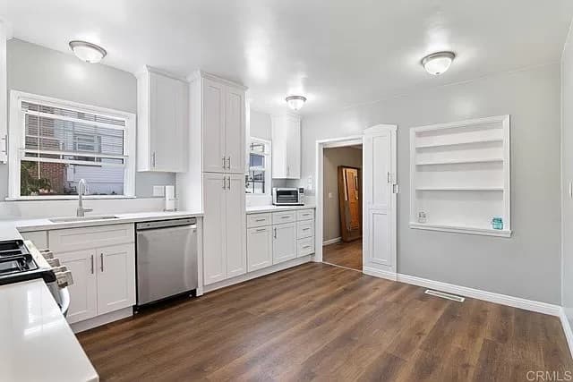 Kitchen interior painting with white cabinetry and wood flooring